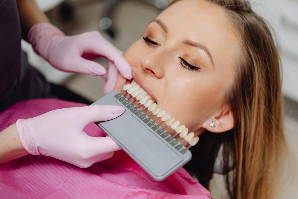 A Dentist Holding a Dental Shade Guide in front of a Patient